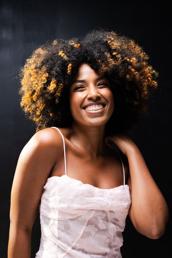 Mujer sonriendo con cabello rizado